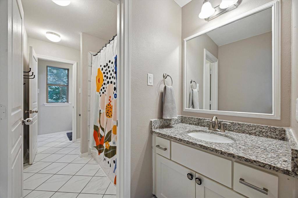 Secondary bath with private vanity area.