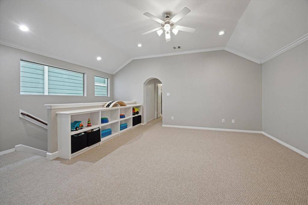 At the top of the stairs awaits a fabulous flex space - second floor living room, gameroom or whatever fits your needs.  The primary suite entrance is the arch doorway at the front of the picture.