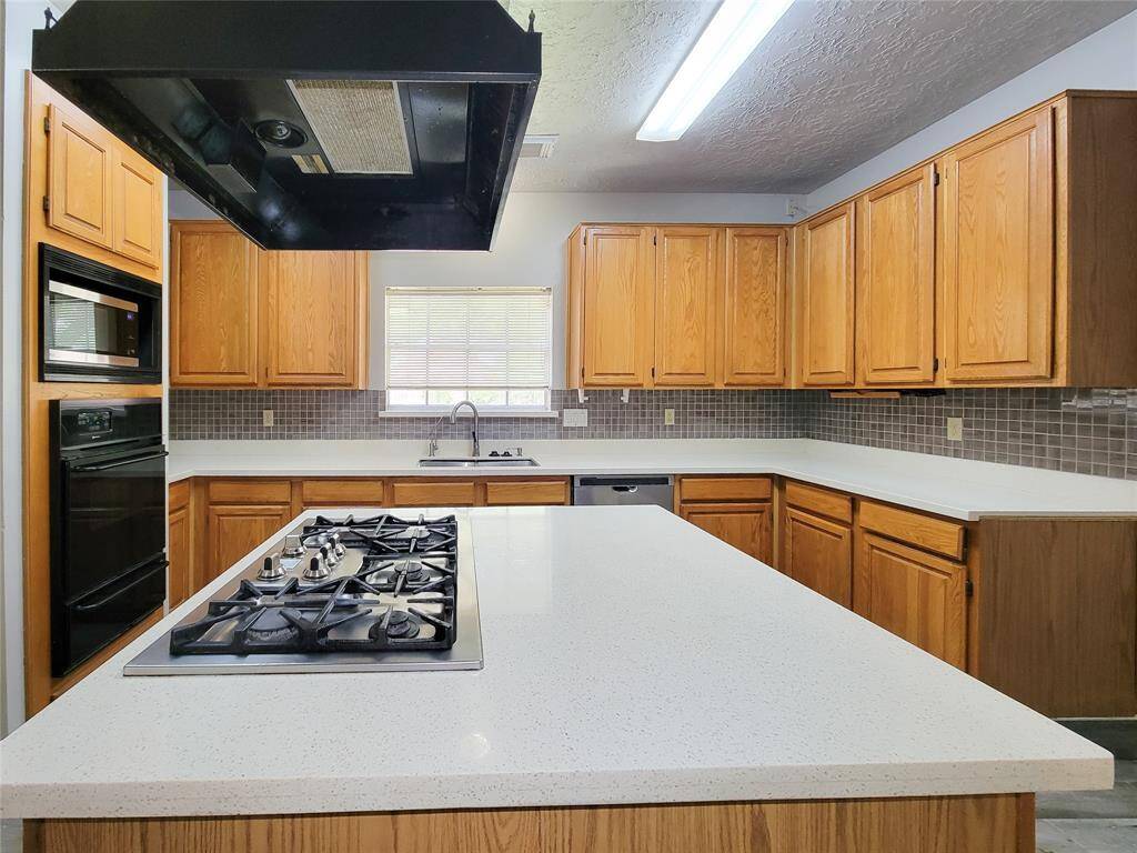 Spacious kitchen featuring sleek countertops, ample cabinet space, and modern appliances. Ideal for culinary enthusiasts and perfect for entertaining.