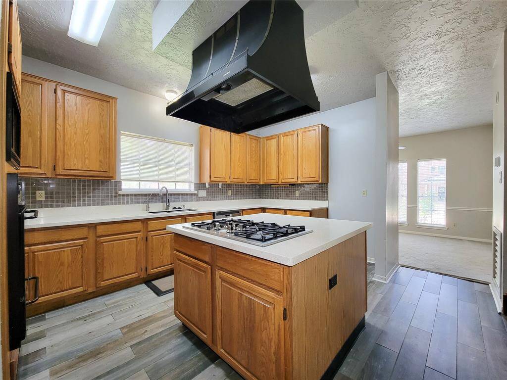 Spacious kitchen with modern appliances, ample storage, and a convenient island cooktop. Bright and inviting with large windows, ideal for culinary enthusiasts and entertaining.