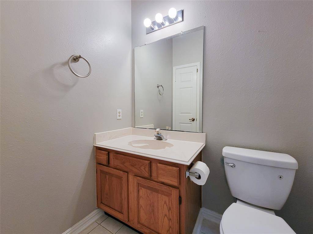 This bathroom offers a clean and functional design, featuring a spacious vanity with ample storage and a large mirror. Its neutral tones create a bright and inviting atmosphere, perfect for any home.