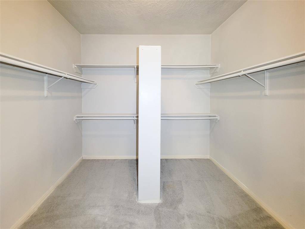 Spacious walk-in closet featuring ample shelving and hanging space, perfect for organizing your wardrobe efficiently.