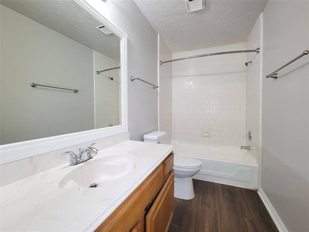 Modern bathroom featuring a sleek vanity, elegant fixtures, and a classic tub-shower combo. The bright, neutral palette enhances the spacious feel, perfect for relaxation and comfort.