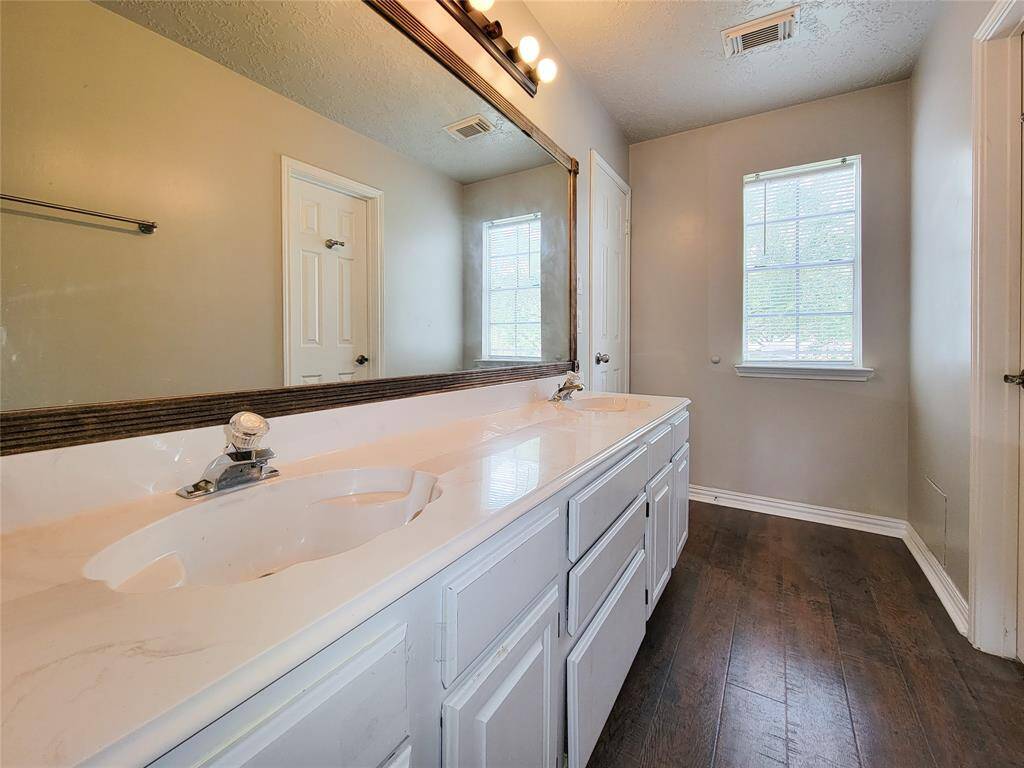 Experience elegance in this spacious bathroom featuring a stylish double vanity, sleek fixtures, and abundant natural light. Perfect for a refreshing start to your day.