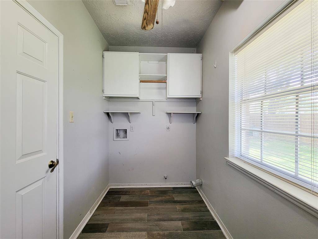 This bright and functional laundry room features ample storage, a utility sink, and a window for natural light. It's perfectly designed for convenience and efficiency.