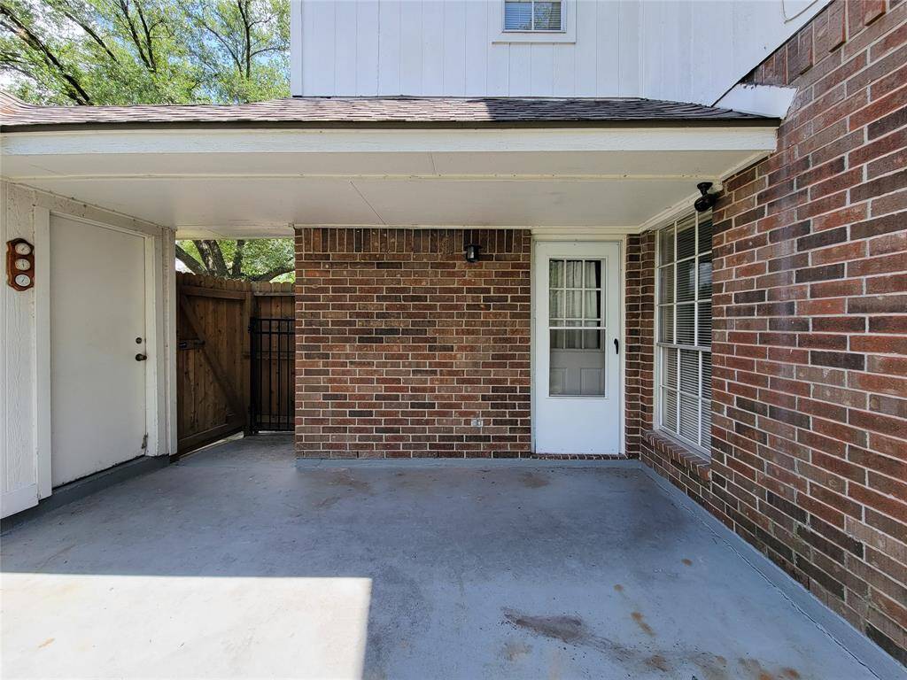 Charming covered patio with brick accents offers a cozy outdoor space, ideal for relaxation or entertaining. Enjoy privacy with a fenced yard and convenient access through the side door.