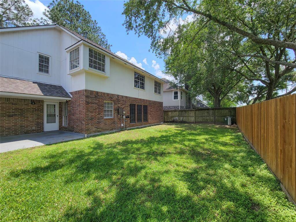 Spacious backyard with lush greenery, perfect for outdoor activities and relaxation. The home features a charming brick exterior with ample natural light, nestled in a peaceful neighborhood. Ideal for families seeking comfort and privacy.