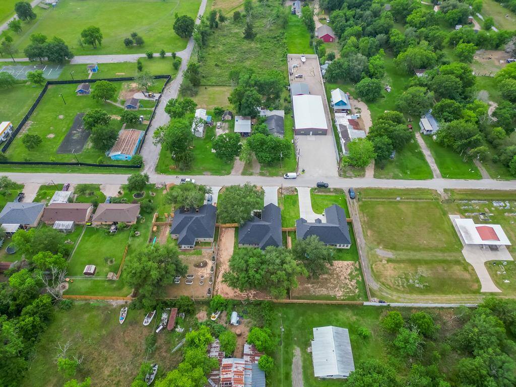 This aerial photo showcases a suburban neighborhood with spacious yards and mature trees. The area features well-maintained homes and open green spaces, offering a peaceful and family-friendly environment.