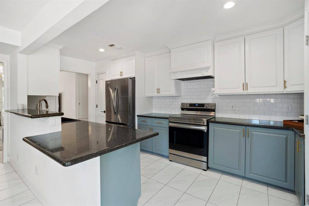 The renovated kitchen has recent stainless appliances and a breakfast bar.  Two pantries make for plenty of storage.