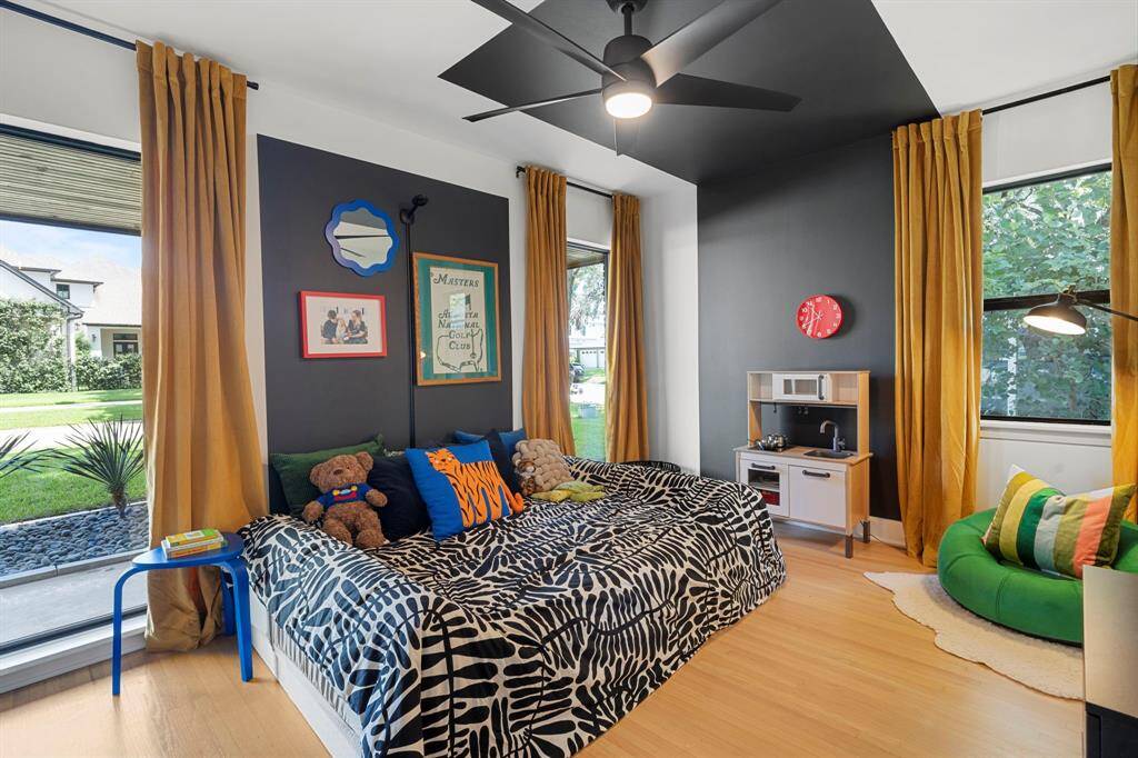 Sizable secondary bedroom at the front of the house with wood floors, ceiling fan and high efficiency windows.