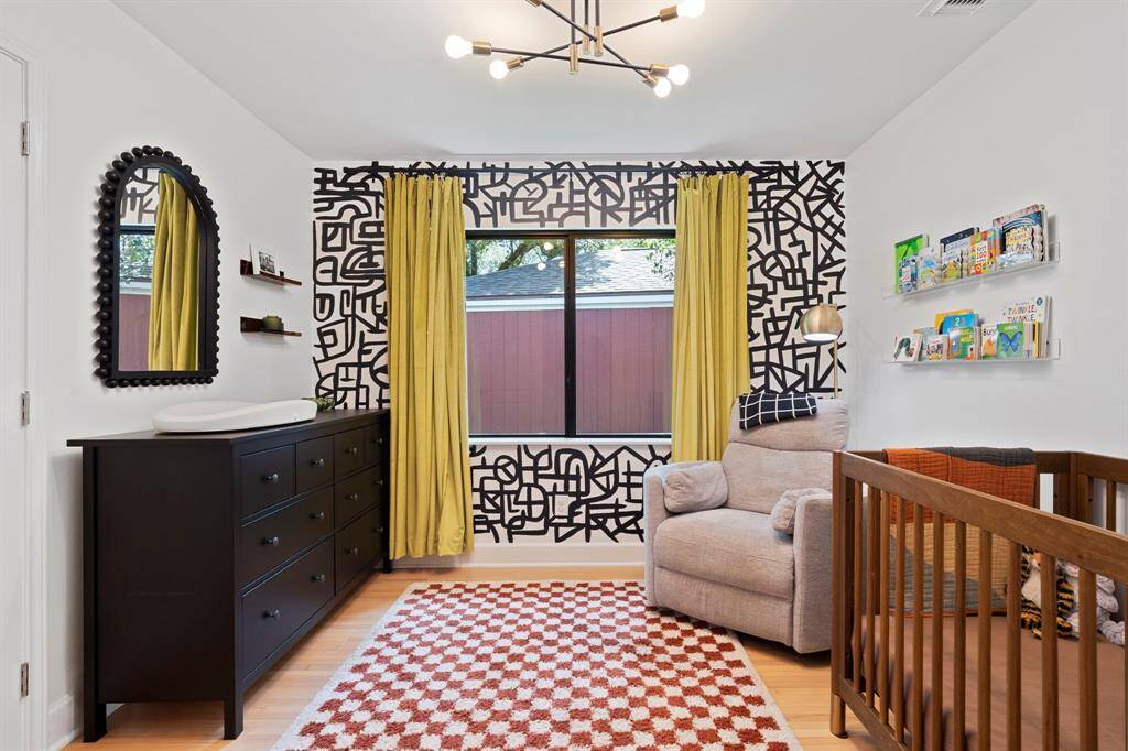 Middle bedroom with wood floors, modern lighting, high efficiency windows and Elfa door organizing systems in closet.