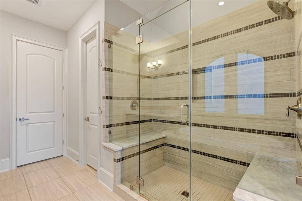 Oversized double shower with beautiful mosaic tiles complete this space.