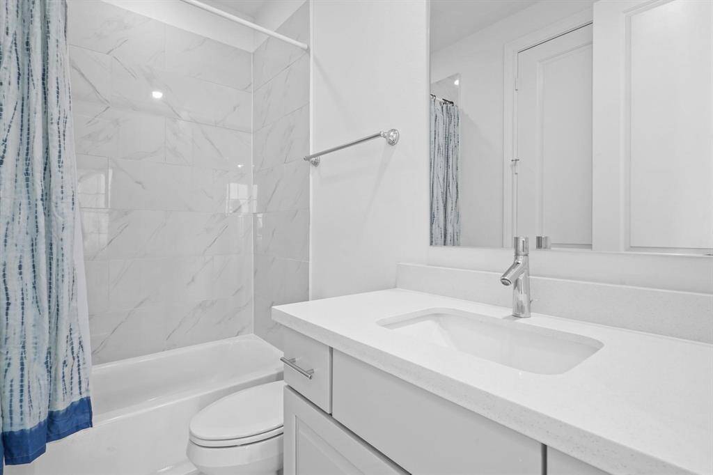 This private full bathroom complements the spacious first-floor bedroom, offering modern fixtures, ample counter space, and convenient access to the walk-in closet.