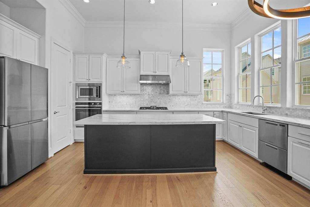 Discover a bright and expansive kitchen with ample counter space, a stylish island, and plenty of natural light.