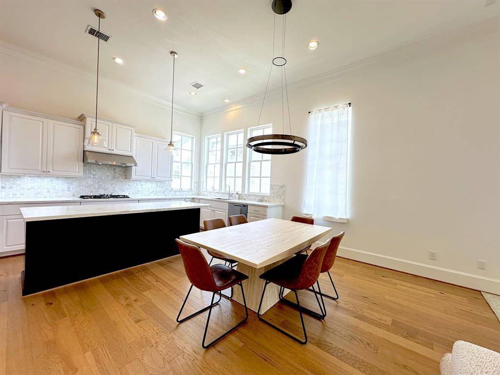Dine in style! This open-concept space seamlessly connects the modern kitchen with a chic dining area, perfect for entertaining.