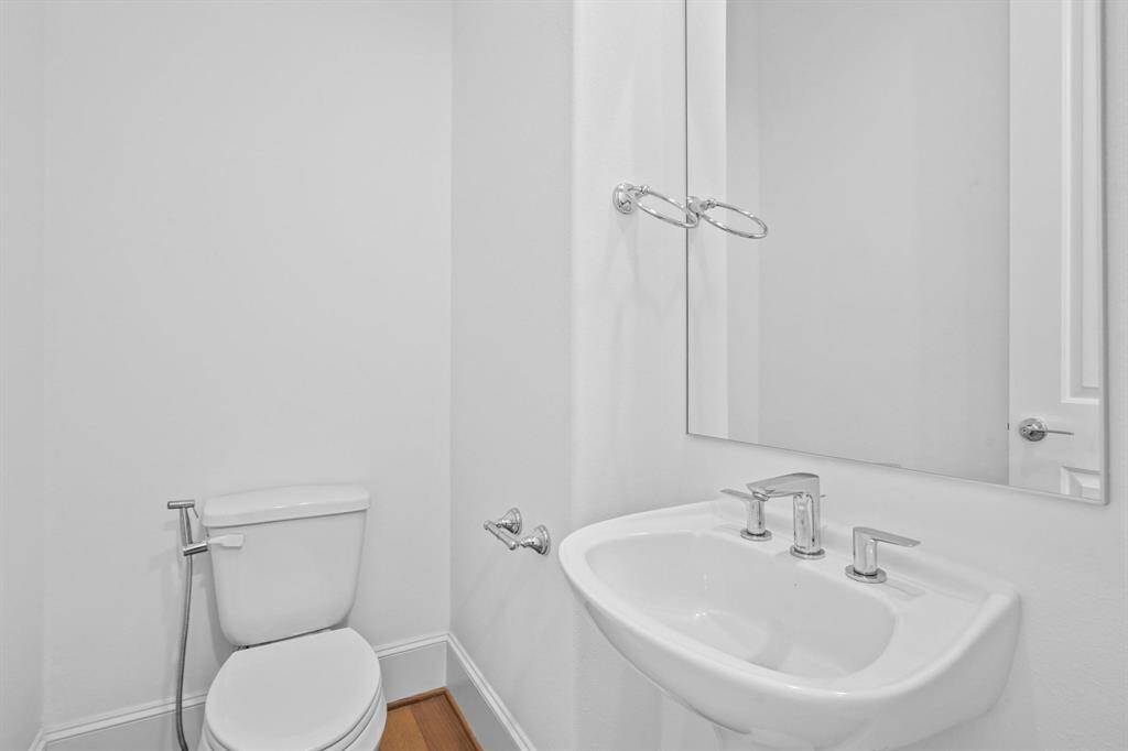 Conveniently located for guests, this stylish half bathroom on the middle floor offers modern comfort and ease.