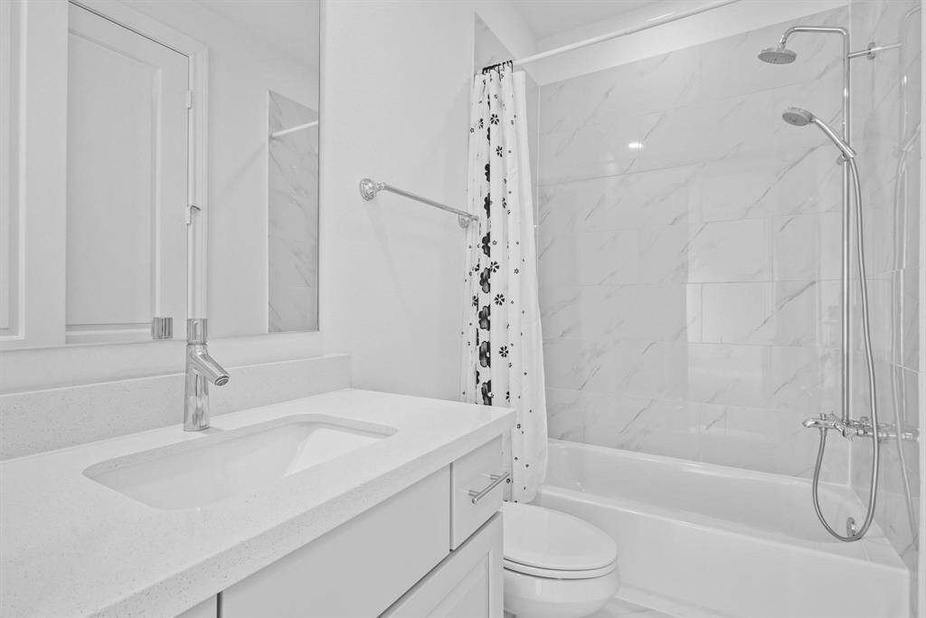 This private full bathroom complements the spacious first-floor bedroom, offering modern fixtures, ample counter space, and convenient access to the walk-in closet.