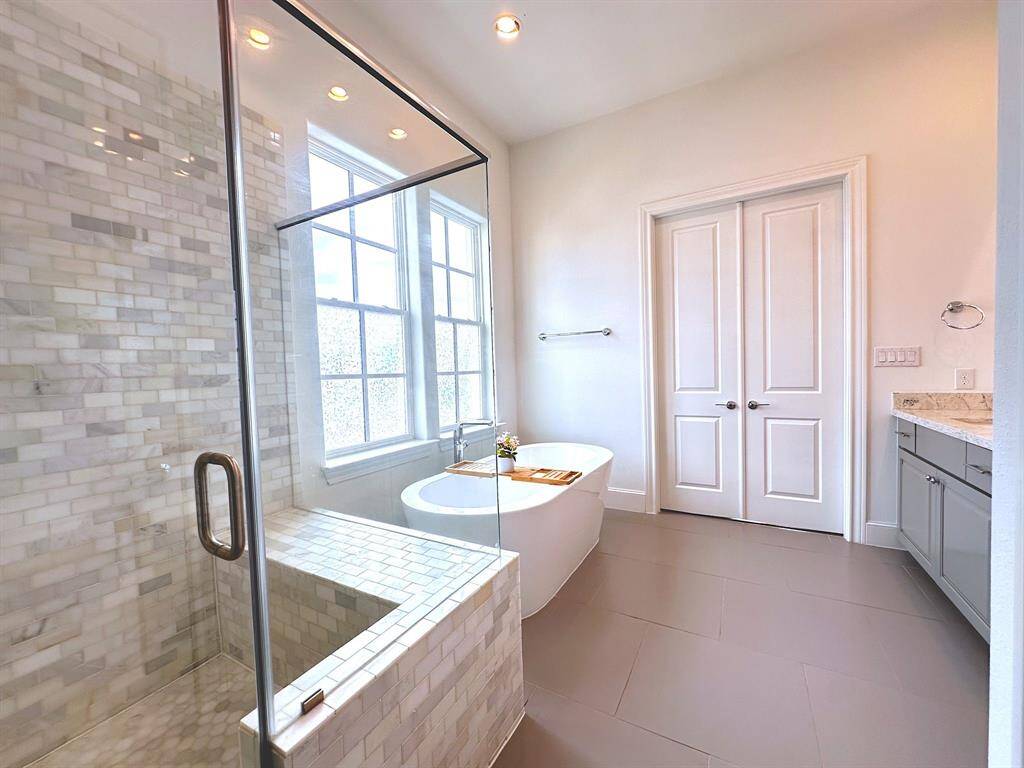 Luxurious and spacious. This primary bathroom features a freestanding tub, a separate shower, and double sinks, creating a spa-like retreat.
