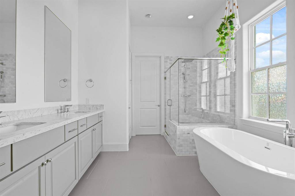 Luxurious and spacious. This primary bathroom features a freestanding tub, a separate shower, and double sinks, creating a spa-like retreat.
