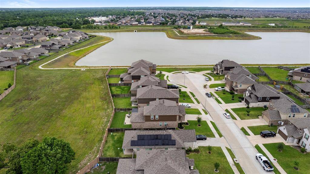 This photo showcases a suburban neighborhood with spacious homes, neatly arranged on a cul-de-sac. The properties have well-maintained lawns and are adjacent to a large, scenic pond, providing a peaceful and attractive setting.