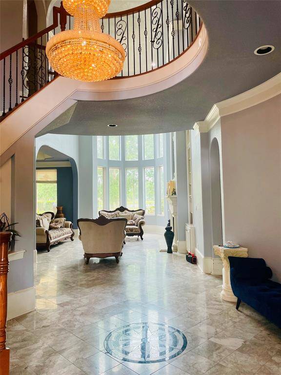 View from entry. Marble floors, grand chandelier with spiral staircase.