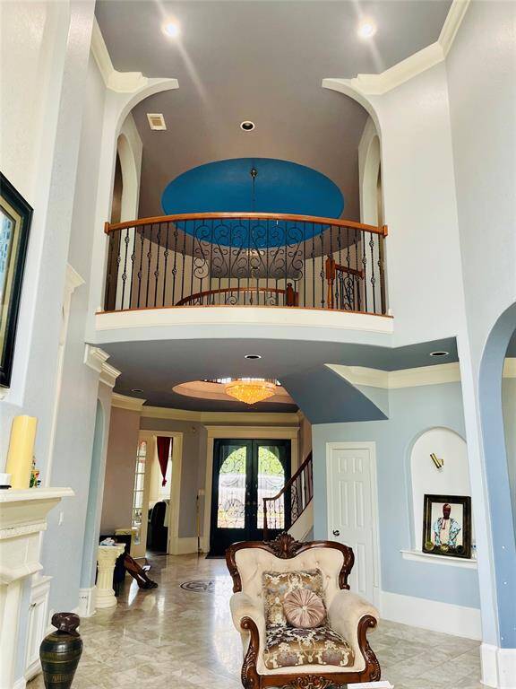 View of the front entry, soaring ceilings, and balcony off of the spiral staircase