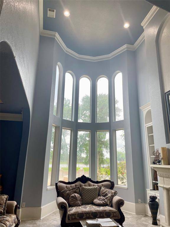 Crown Molding, majestic view of the pool and lake from the formal living. Fireplace off to the right.