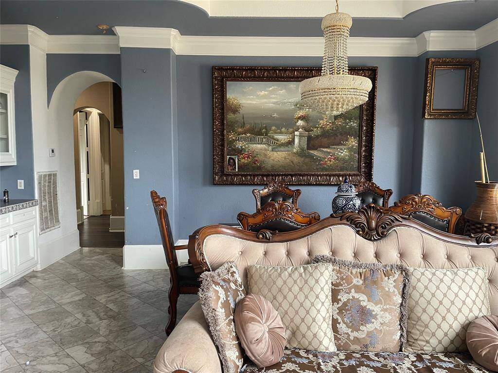 View of formal dining room from the formal living room.  Notice the details in the flooring,  moulding, tray ceiling, built-in buffet with hutch to the left