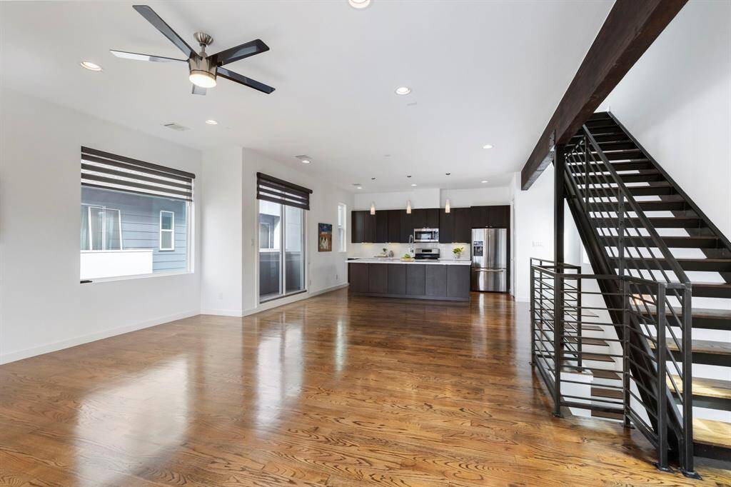 Exposed beam and staircase delight from every angle. Hardwood flooring gleams.