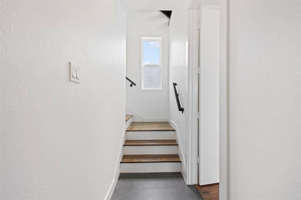 As you enter through front door, staircase leads to main living area. To the right is a 1st floor bedroom/flex room.