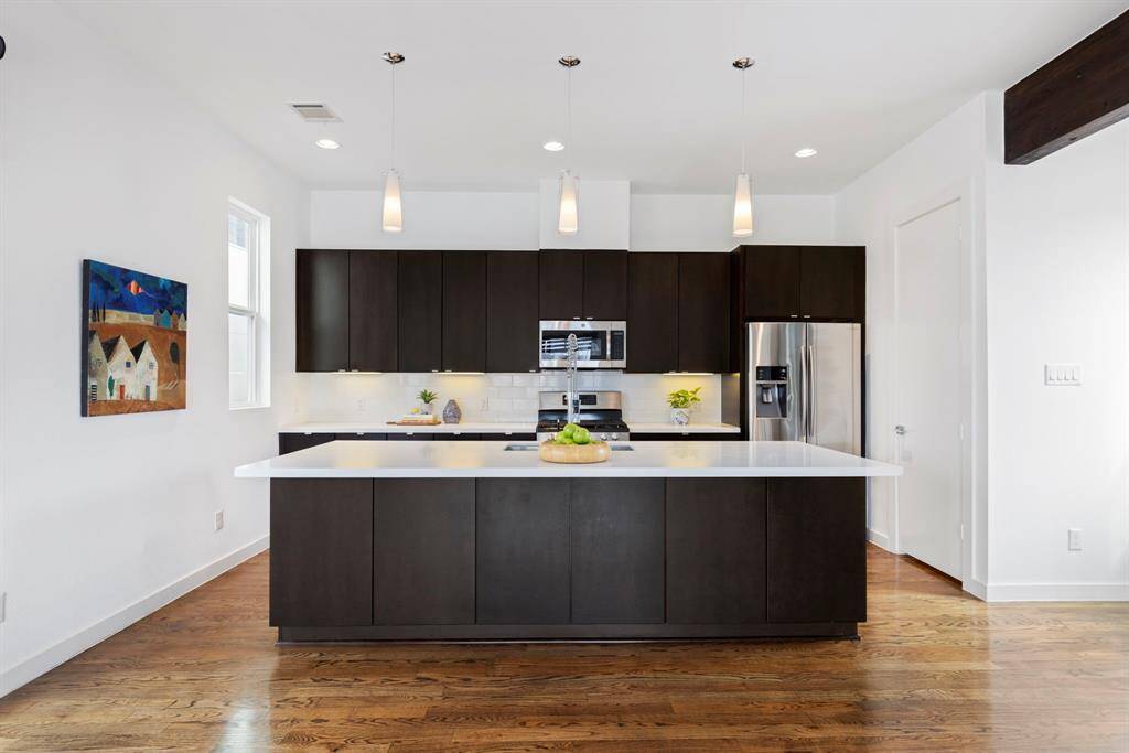 Modern kitchen offers sophisticated design choices and thoughtful storage spaces, including cabinets beneath island seating.