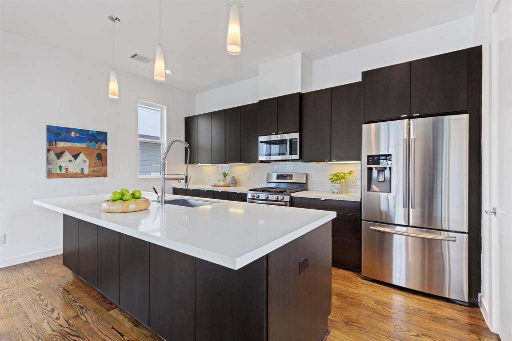 Designer flat front cabinets in Espresso, high end stainless steel GE appliances.