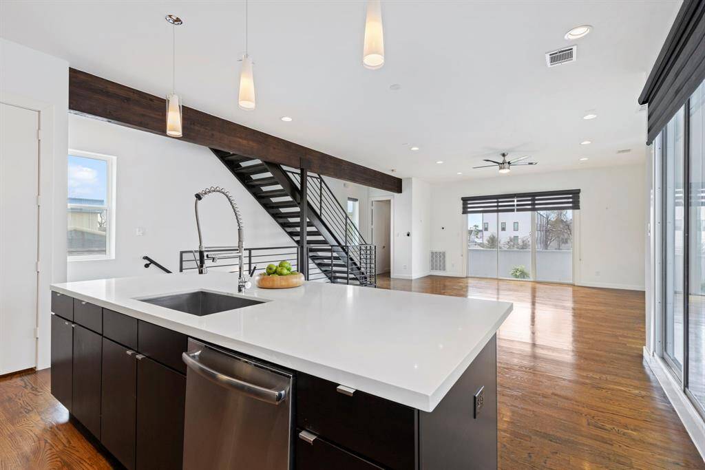 Exposed beam and steel staircase impress architecturally. Abundant natural light highlights the sophistication of this open living space.
