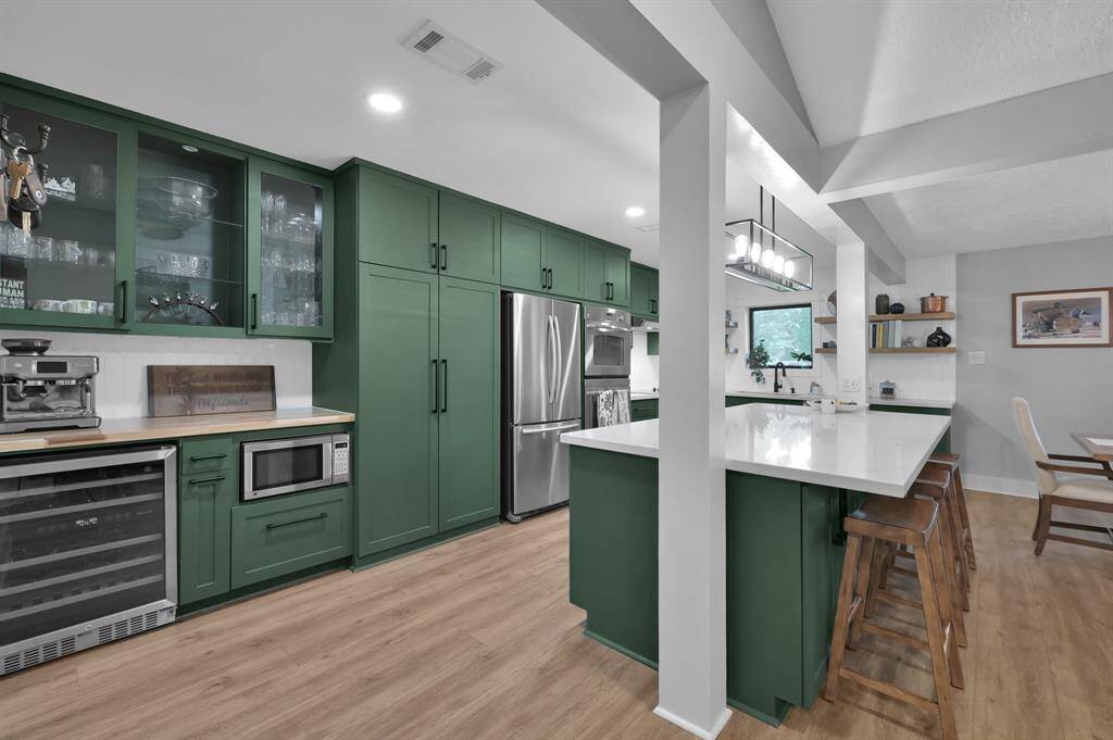 The kitchen was fully renovated in 2021 including an undercounter microwave, extended quartz countertops, glass front custom cabinets, new sink and lighting, and a wine fridge.