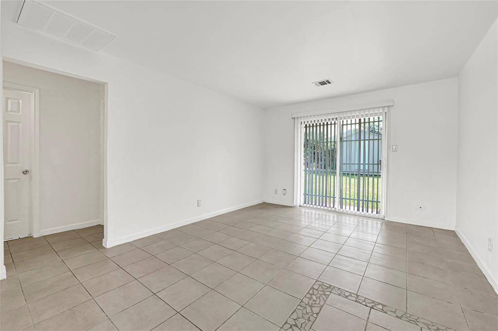 The living area features a clean, minimalist design with white walls and light gray tile flooring to add your own special touch. ***Virtually Staged***