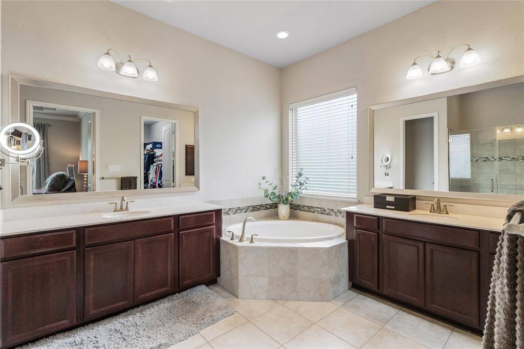 Ensuite primary bathroom features dual vanities and a large soaking tub.