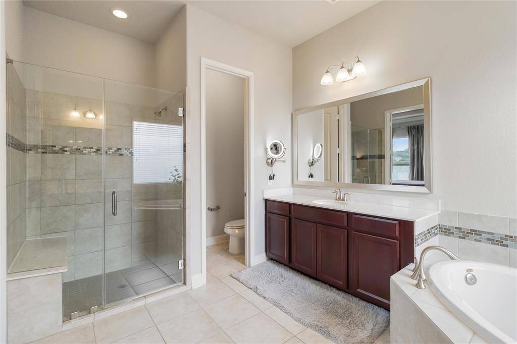 Separate frameless glass-enclosed shower.