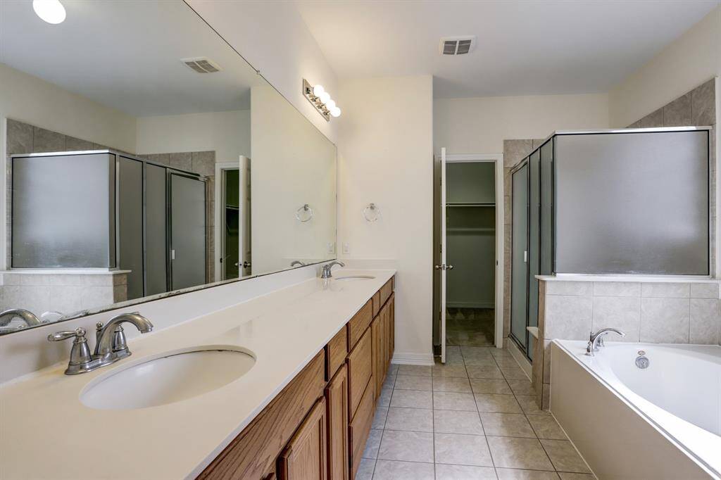 Relax and refresh in the primary bathroom—soaking jetted tub, dual sinks, standalone shower, and plenty of closet space.
