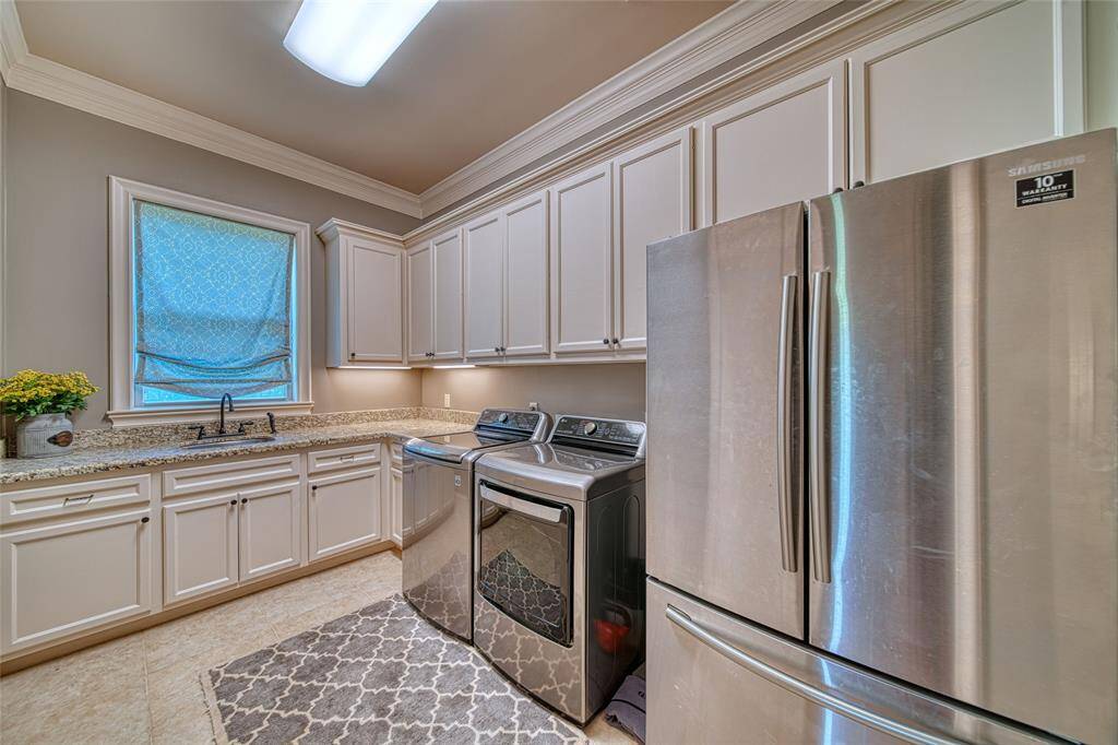 Even the Laundry Room is Beautiful in this Home! Tons of cabinets for storage, Sink, and fridge !