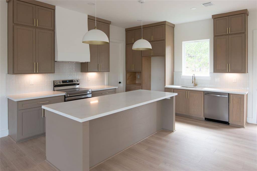 Open concept kitchen with custom oak cabinetry, quartz countertop, soft closing drawers and walk-in pantry.