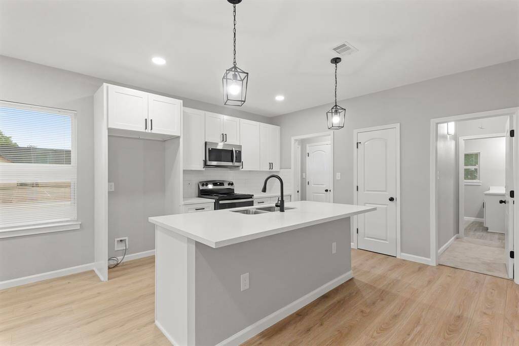 Your chef inspired kitchen awaits! Features include granite countertops paired with a coordinating backsplash, stainless steel appliances, crisp white cabinets with updated hardware, recessed lighting, pendant lighting and a sprawling island with breakfast bar seating.