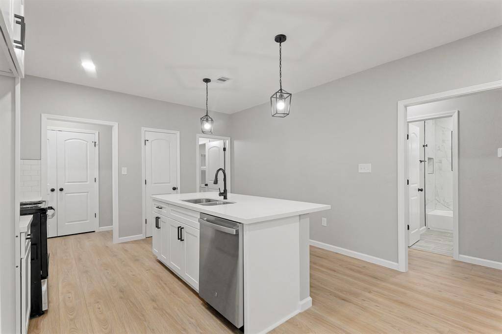 The sprawling island with breakfast bar seating serves as a versatile centerpiece, providing additional workspace, storage, and seating for casual dining or entertaining.