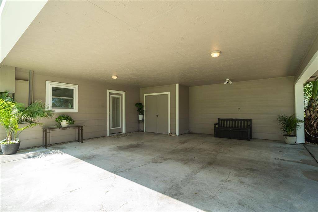 Two car carport with home access and a storage closet