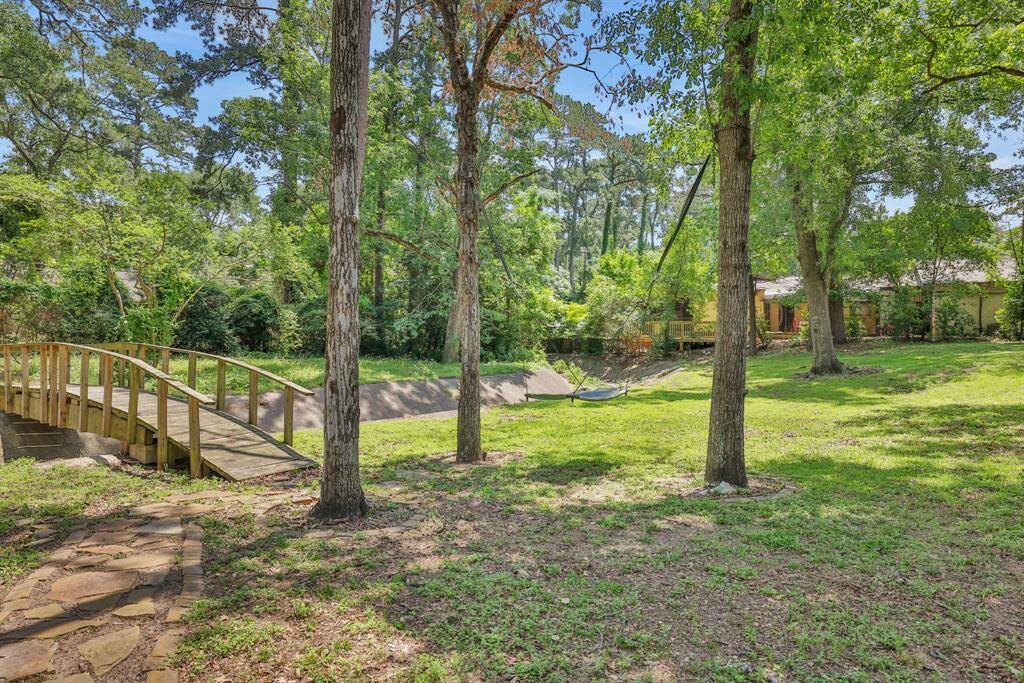 Expansive Backyard. Over an acre of tree-filled land, perfect for outdoor activities and gardening.