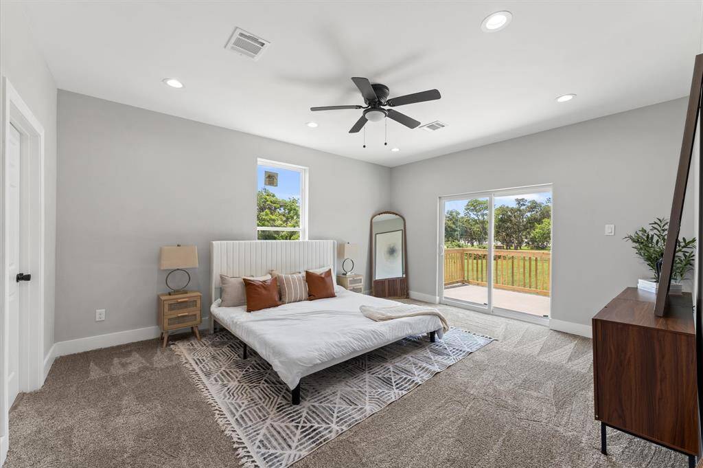Spacious primary bedroom with direct balcony access and serene lake views.