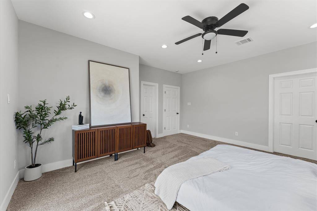 Spacious primary bedroom with direct balcony access and serene lake views.