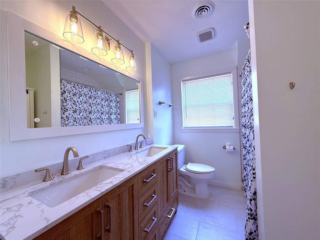 Between the front and back bedroom, the hallway/guest bath, has been nicely updated and offers an extended vanity with double sinks. The vanity drawers are soft-closing.