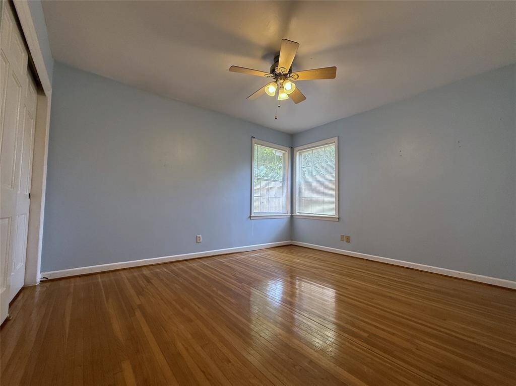 With ceiling fan, the back bedroom is finished with calming blue walls.