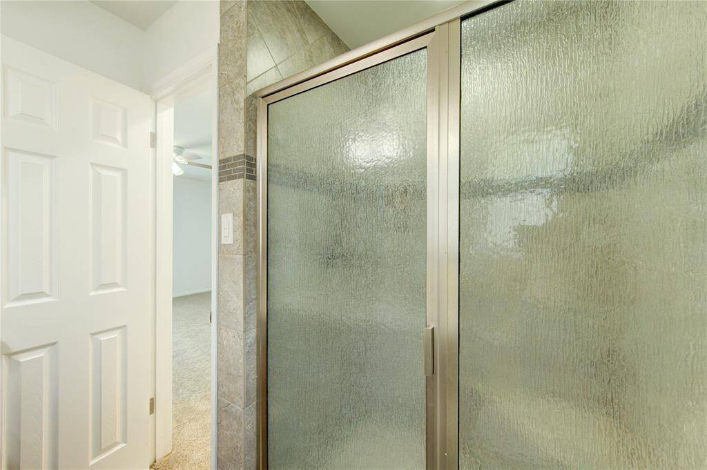 Upgraded tile shower with built in seat. Pebble glass shower door.