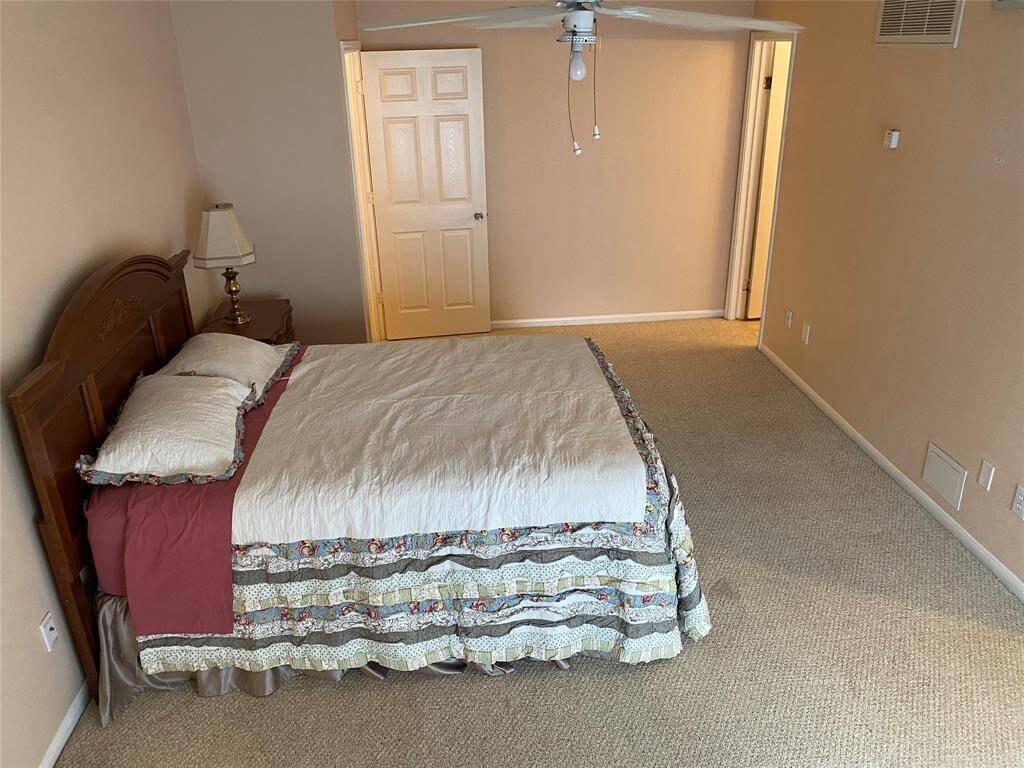 This bedroom features a space with neutral walls and carpet, a ceiling fan, and ample natural light. Offering a comfortable and inviting atmospher.